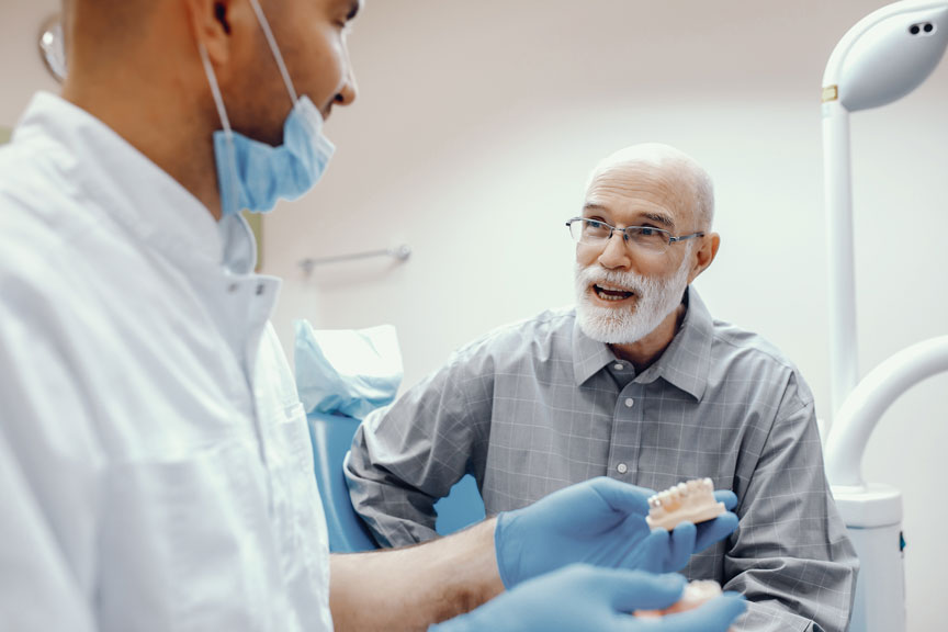 Dentist Explaining Denture Treatment To The Patient