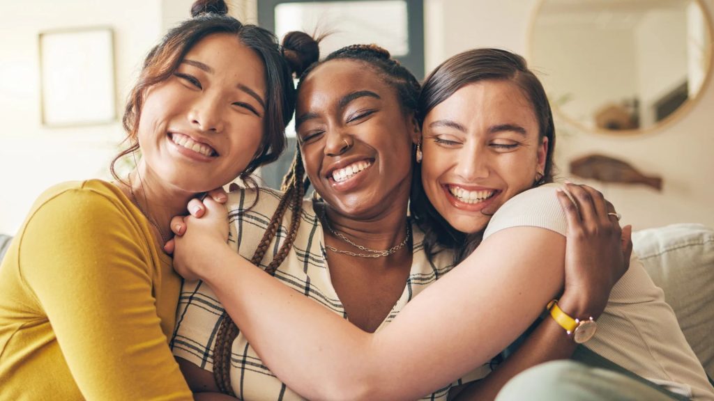 Happy Women Hugging And Smiling Together